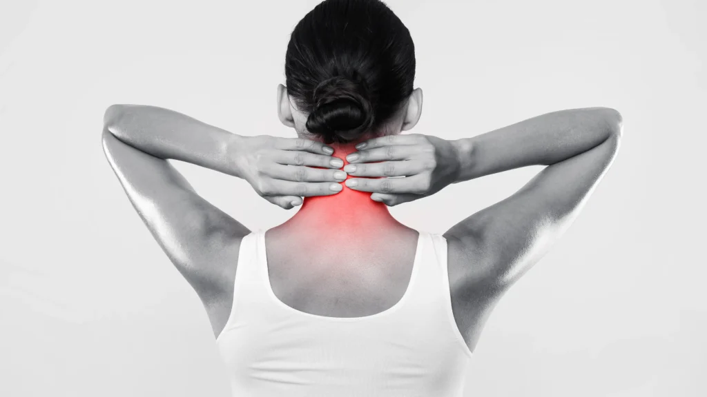 Black and white photo of a woman holding the back of her neck, that's radiating pain due to complications from Arthritis