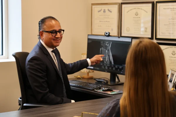 Pain management doctor with patient reviewing scans