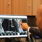 Dr. Moise Reviewing Scans of A Chiari Malformation patient, pointing at the Screen