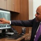 Dr. Moise Reviewing Scans of A Chiari Malformation patient, pointing at the Screen