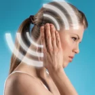 Woman holding her ear as a result of ringing in her ear from Pulsatile Tinnitus