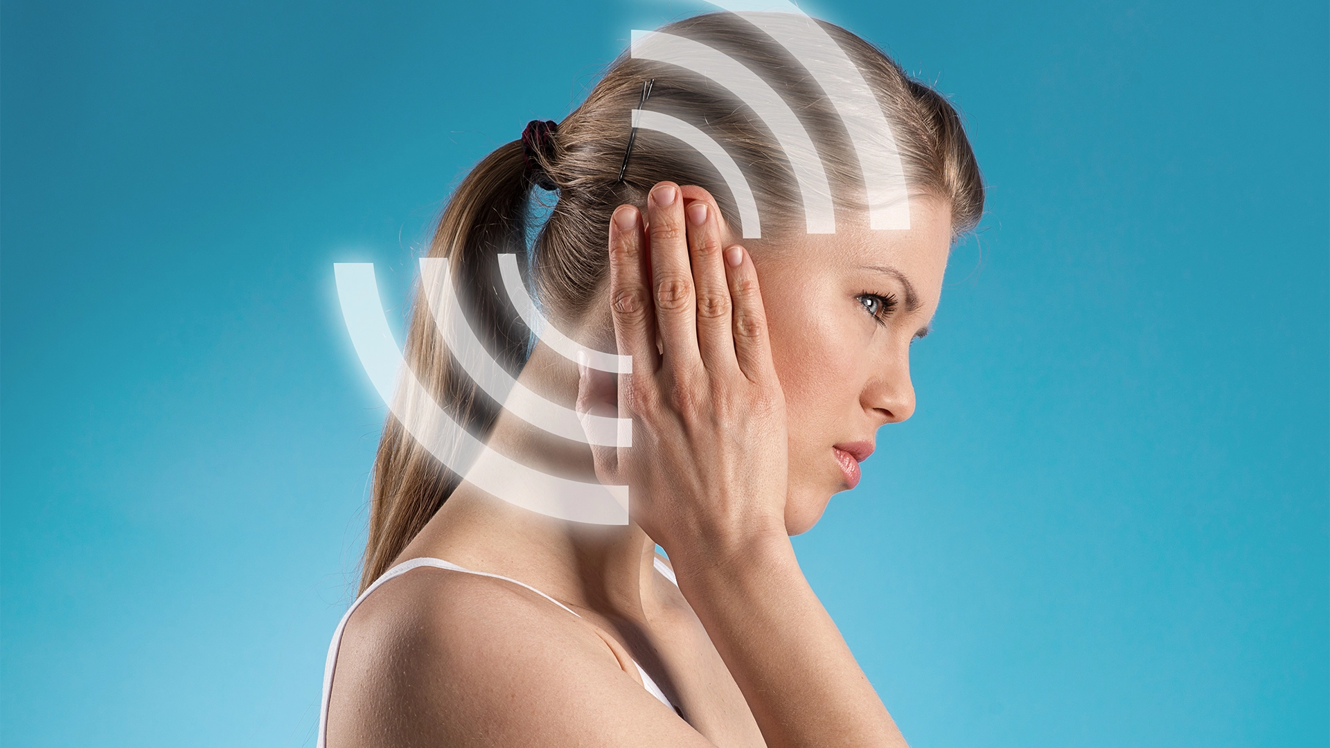 Woman holding her ear as a result of ringing in her ear from Pulsatile Tinnitus