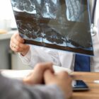 At a health screening, a doctor is looking at MRI data.