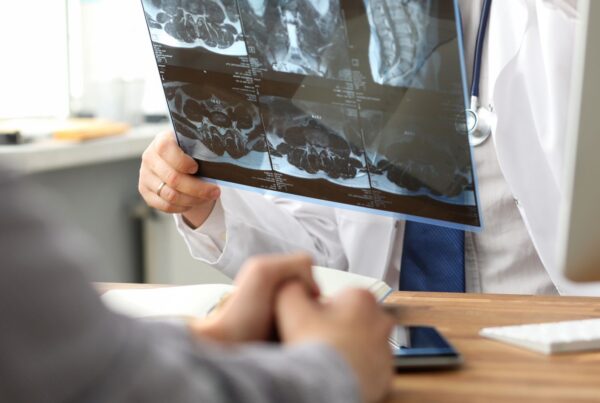 At a health screening, a doctor is looking at MRI data.